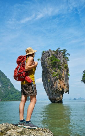 Traveller looking out at a limestone island in Phang Nga Bay, Thailand